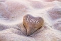 Love concept, heart on the sand