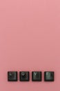 Love concept with keyboard letters on pink background.  Vertical view Royalty Free Stock Photo