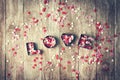 Love concept with letters LOVE and sweethearts on old wooden background, vintage toning. Top view with copy space Royalty Free Stock Photo