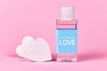 Love concept with plastic bottle filled with liquid and made up label saying `45ml concentrated LOVE` on pink background