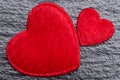 Love concept: Two red fluffy hearts over rough black slate background