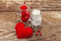 Love concept for Valentines day or mothers day. Red felt heart, glass jar, roses, ribbons. Old wooden boards background Royalty Free Stock Photo