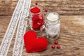 Love concept for Valentines day or mothers day. Red felt heart, glass jar, roses, ribbons. Old wooden boards background Royalty Free Stock Photo