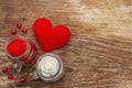 Love concept for Valentines day or mothers day. Red felt heart, glass jar, roses, ribbons. Old wooden boards background Royalty Free Stock Photo