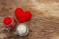 Love concept for Valentines day or mothers day. Red felt heart, glass jar, roses, ribbons. Old wooden boards background Royalty Free Stock Photo