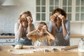 Cute multigenerational family make glasses from cookies hearts at kitchen