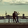 A love couple does srlfie on the embankment