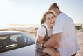 Love, couple and happy while on road trip laugh, playful and relax loving on holiday and at beach sit on car outdoor Royalty Free Stock Photo