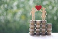 Love couple holding heart shape standing on stack of coins money on natural green background, Saving for lover or family and save Royalty Free Stock Photo