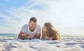 Love, couple and laying on sand at beach, happy and bonding on vacation, loving or together outdoor for romance Royalty Free Stock Photo