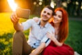 Love couple makes selfie in summer park on sunset Royalty Free Stock Photo