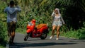 Love couple on red motorbike in white clothes, sunglasses on forest road trail trip. Dancing road. Two caucasian tourist Royalty Free Stock Photo