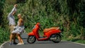 Love couple on red motorbike in white clothes, sunglasses on forest road trail trip. Dancing road. Two caucasian tourist Royalty Free Stock Photo