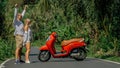 Love couple on red motorbike in white clothes, sunglasses on forest road trail trip. Dancing road. Two caucasian tourist Royalty Free Stock Photo