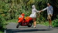 Love couple on red motorbike in white clothes, sunglasses on forest road trail trip. Dancing road. Two caucasian tourist Royalty Free Stock Photo