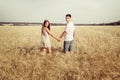 Love couple walking in field holding hands Royalty Free Stock Photo