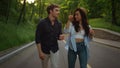 Love couple walking on road. Joyful girl and guy jumping on road outdoors.