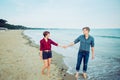 Love couple walking on sea shore holding hands in beach vacation. Concept of lovers happy moments on holiday. Boyfriend and girlfr Royalty Free Stock Photo