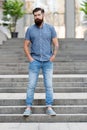 In love with denim. Man bearded hipster fashion model wear denim clothes urban background stairs. Regular walk in city Royalty Free Stock Photo