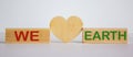 `We love earth` words concept on wooden blocks. White background. Wooden hearts