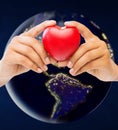 Hands holding red heart over earth in space Royalty Free Stock Photo