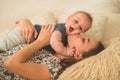 Love and family. Home portrait of a baby boy with mother on the bed. Mom play and kissing her child Royalty Free Stock Photo