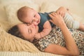 Love and family. Home portrait of a baby boy with mother on the bed. Mom play and kissing her child Royalty Free Stock Photo