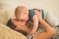 Love and family. Home portrait of a baby boy with mother on the bed. Mom play and kissing her child Royalty Free Stock Photo