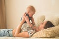 Love and family. Home portrait of a baby boy with mother on the bed. Mom play and kissing her child Royalty Free Stock Photo