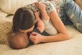 Love and family. Home portrait of a baby boy with mother on the bed. Mom play and kissing her child Royalty Free Stock Photo