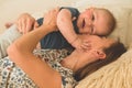 Love and family. Home portrait of a baby boy with mother on the bed. Mom play and kissing her child Royalty Free Stock Photo