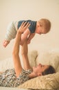 Love and family. Home portrait of a baby boy with mother on the bed. Mom play and kissing her child Royalty Free Stock Photo