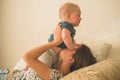 Love and family. Home portrait of a baby boy with mother on the bed. Mom play and kissing her child Royalty Free Stock Photo