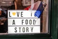 `Love is a food story` sign in the window of a restaurant