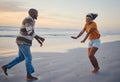 Love, freedom and couple at a beach at sunset, laughing and having fun on summer vacation in nature. Relax, sea and Royalty Free Stock Photo