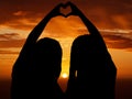 Love, freedom and heart sign by couple silhouette of lesbian and lgbt pride, hand shape at sunset. Women celebrate Royalty Free Stock Photo