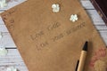 Love God, love your neighbor handwritten text verse on vintage paper with closed bible book and pen on wooden table