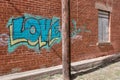 Love graffiti on outside of building with red brick