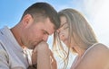 Love, hand and couple kiss at a beach, sharing intimate moment of romance at sunrise against blue sky background. Travel Royalty Free Stock Photo