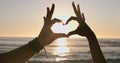 Love, hands and heart on beach with sunset, water background and horizon for vacation, travel or adventure. People, man