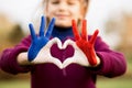 Love and happiness concept. Cute child forming heart gesture with hands outdoors on nature sunset background. Heart Royalty Free Stock Photo