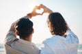 Love, heart hands and gay men on beach, hug from back on summer vacation together in Thailand. Sunshine, ocean and Royalty Free Stock Photo