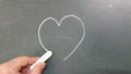 Love hearts drawing on a school chalkboard, kids hand Royalty Free Stock Photo