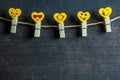 Love Hearts yellow emotions or emoticons clothespins or pegs on a rope on wooden rustic vintage background
