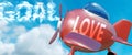 Love helps achieve a goal - pictured as word Love in clouds, to symbolize that Love can help achieving goal in life and business,