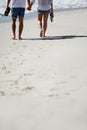 Love, holding hands and legs of couple on beach for date, outdoor bonding and tropical holiday. Romance, man and woman Royalty Free Stock Photo