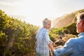 Love, holding hands and nature, senior couple walking with picnic blanket for romance and valentines day. Green mountain Royalty Free Stock Photo