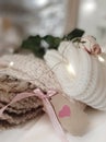 Love holiday concept. Gift tag, pile of knitted sweaters, rose on blurred background.