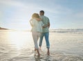 Love, hug and back of couple at the beach walking, bond and relax in nature on blue sky background. Ocean, love and rear Royalty Free Stock Photo