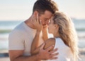 Love, kiss and beach with a young couple sharing an intimate moment on the coast by the sea or ocean. Nature, romance Royalty Free Stock Photo